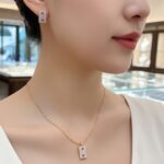Close-up of woman wearing Ruby Accent Rectangle Pendant Set highlighting the ruby-centered pendant and earring