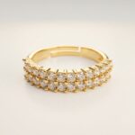 Studio shot of Double Row Brilliance Adjustable Ring on clean background showing two full rows of sparkling round stones and warm gold finish